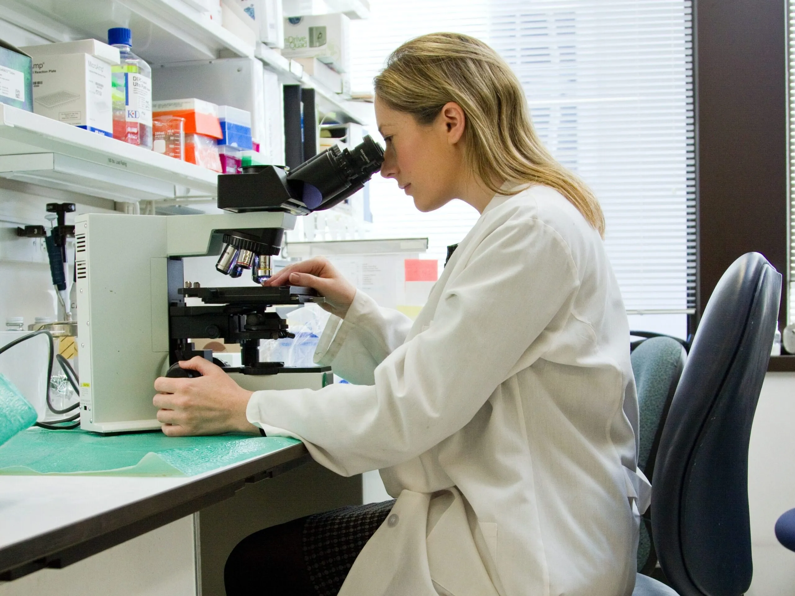 A researcher looking through a microscope in a laboratory.