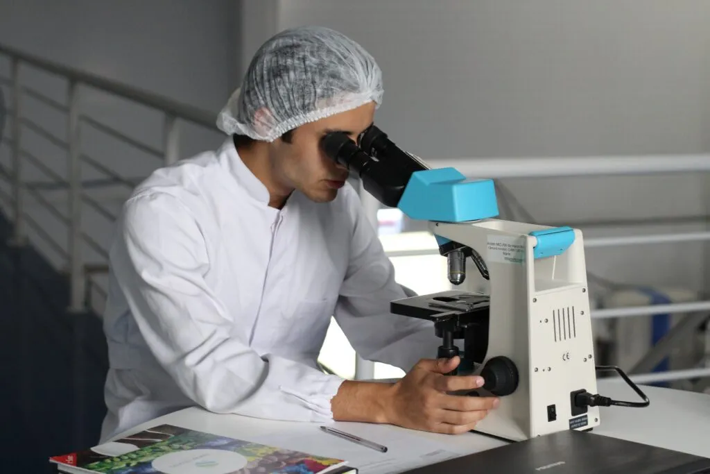 A researcher looking through a microscope in a laboratory.